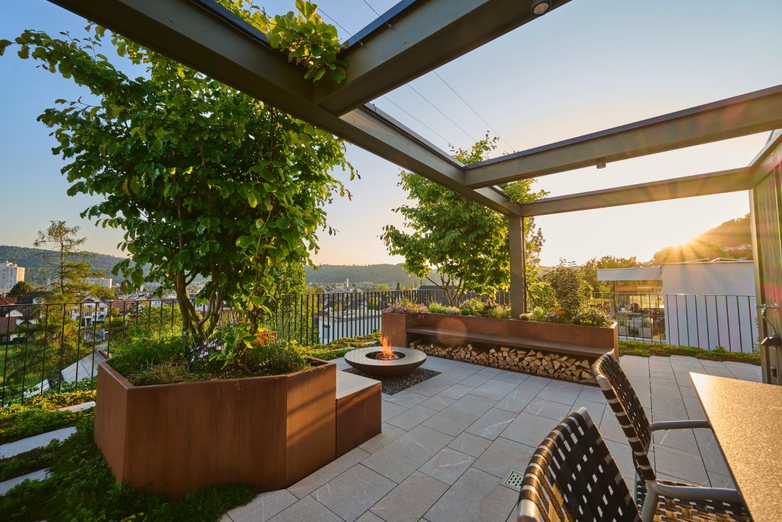 Moderne Terrassengestaltung mit Feuerstelle, Bepflanzung und Sitzbereich, Gartenbau Aargau von Schoop Gartenbau