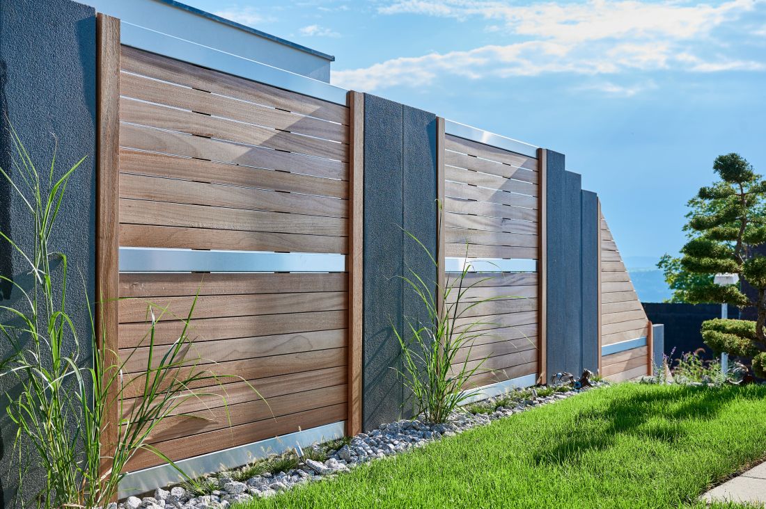 Moderner Sicht- und Lärmschutzzaun aus Holz und Beton im Garten, Gartenbau Aargau von Schoop Gartenbau
