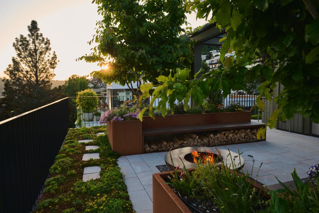 Moderne Gartengestaltung mit Feuerstelle, Sitzbank und Begrünung auf Terrasse, Schoop Gartenbau Aargau
