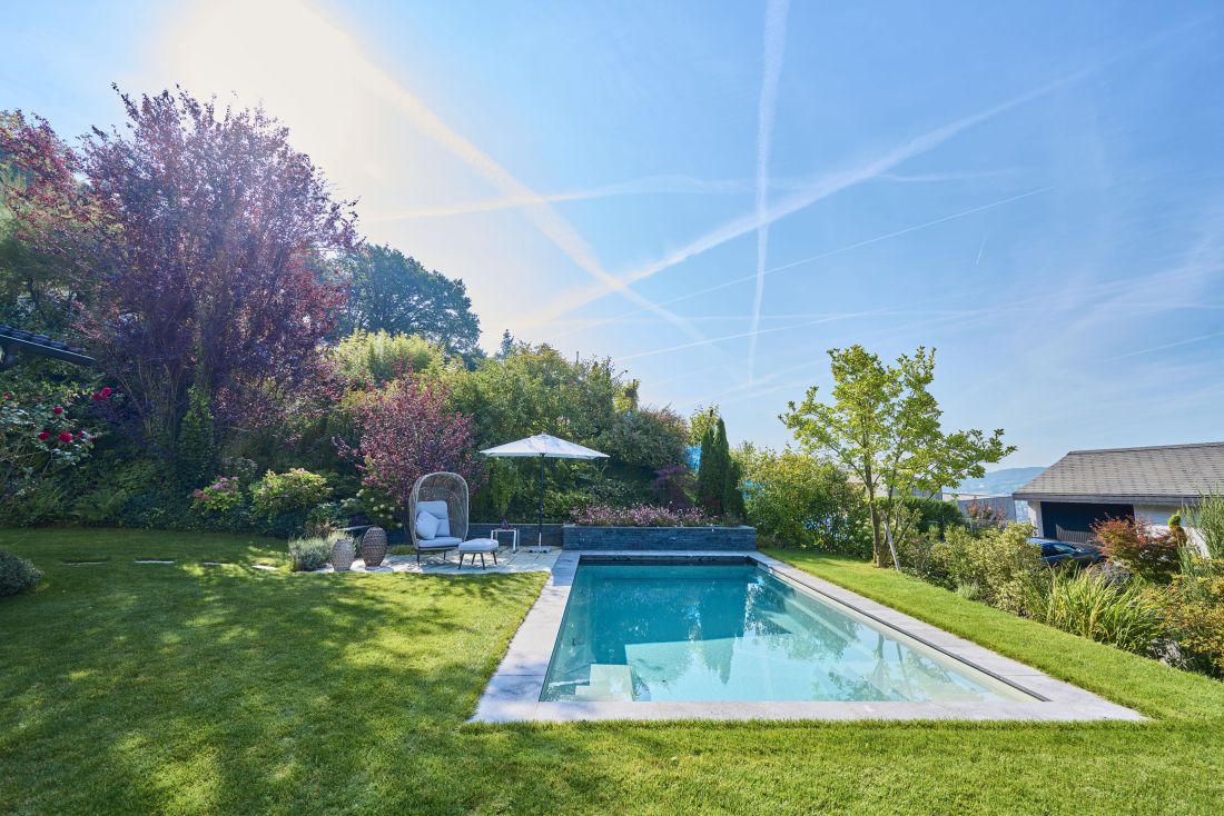 Moderner Garten mit Schwimmbad, Sonnenschirm und Sitzbereich, Gartenbau Aargau von Schoop Gartenbau