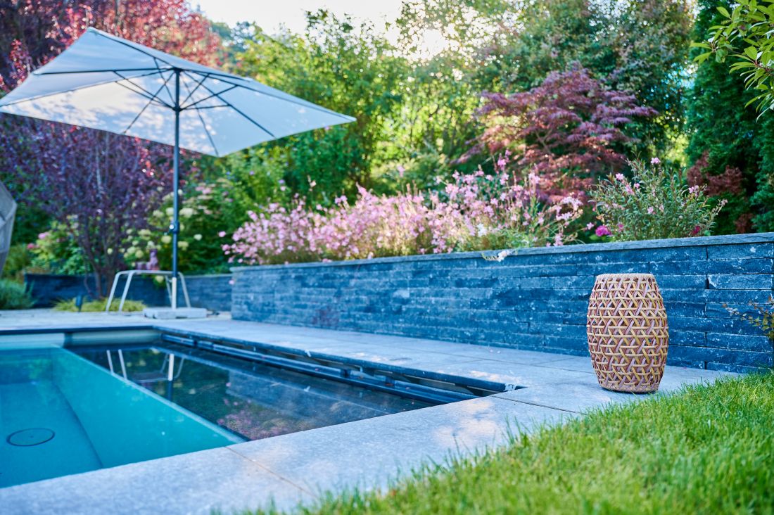 Moderner Garten mit Pool, Sonnenschirm und Blumenbeet, Gartenbau Aargau von Schoop Gartenbau