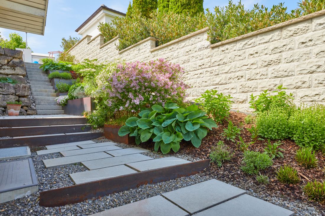 Moderne Gartenanlage mit Treppen, Kiesweg und vielfältiger Bepflanzung für Gartenpflege Schoop Gartenbau Aargau
